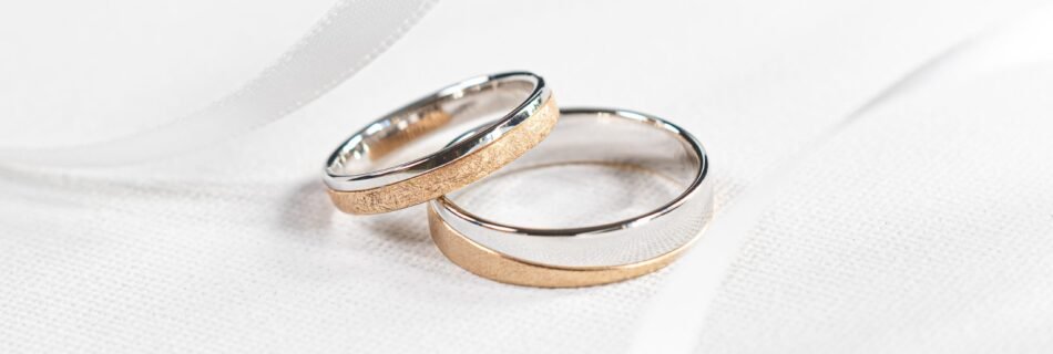 two wedding rings sitting on top of a white cloth